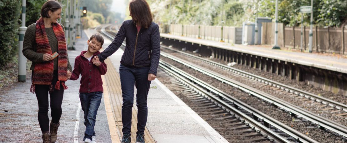 A family walking along the platform of a rural train station