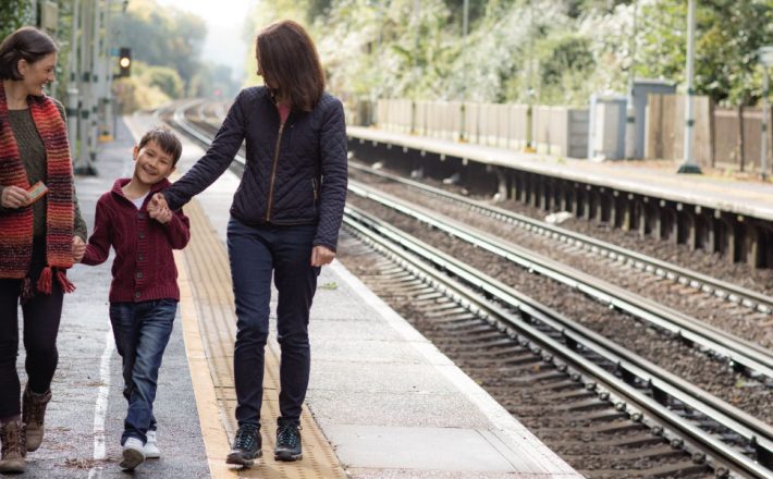 A family walking along the platform of a rural train station