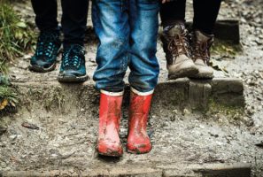 A child's feet wearing red wellies